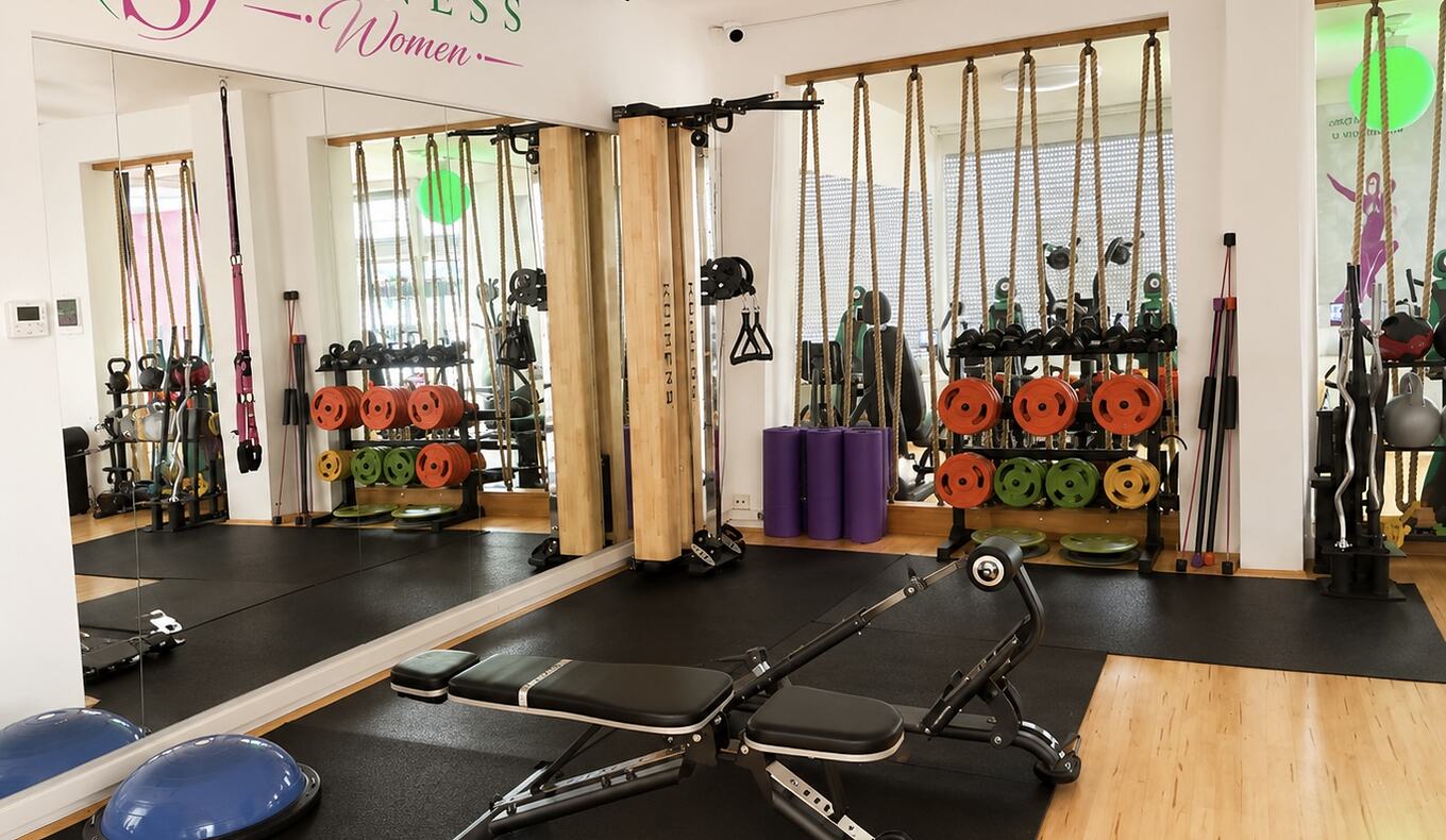 Trainingsbereich für Frauen bei GS Fitness in Wien mit Hantelbank, Seilzug, Gewichtsscheiben und Kleingeräten