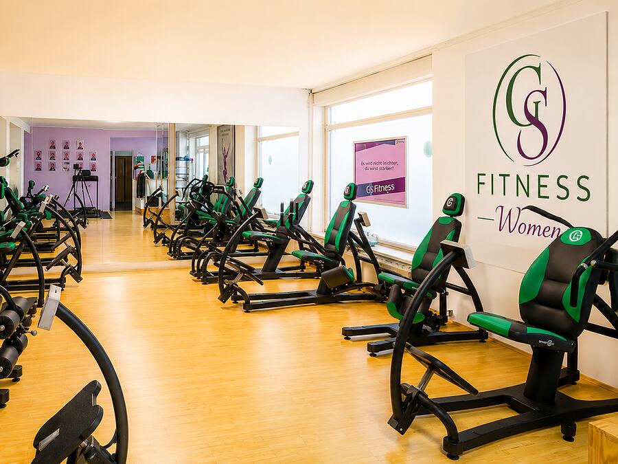 Gerätebereich von GS Fitness in Wien mit Kraftgeräten und dem Wandlogo GS Fitness Women