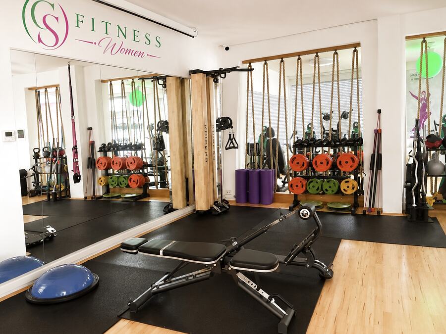 Trainingsbereich von GS Fitness in Wien mit Hantelbank, Seilzug, Gewichtsscheiben und Kleingeraeten